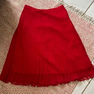 VTG Red pleaded skirt ruffled at bottom. Waist is 24”. Made in England.